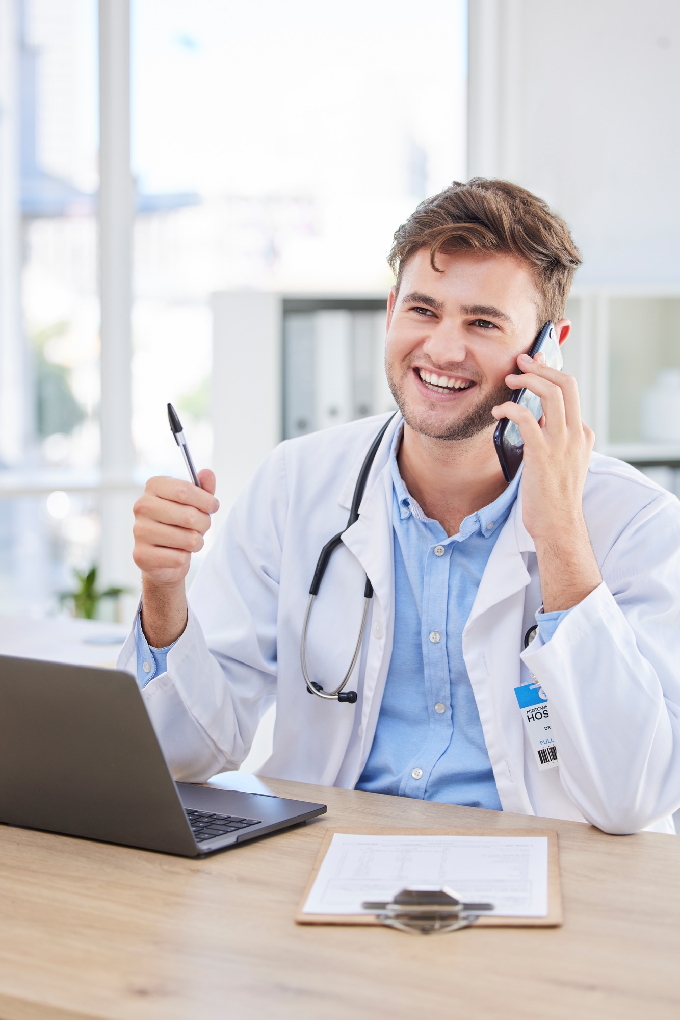 A smiling doctor talking to a patient on his phone